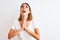 Beautiful redhead woman wearing casual white t-shirt over isolated background begging and praying with hands together with hope