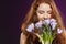 Beautiful redheaded female smelling the crocuses