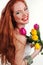 Beautiful redheaded girl is holding tulips