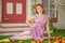 Beautiful redheaded pin up girl in pink polka dot dress and vintage stockings posing near the entrance of her home