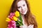 Beautiful redheared girl with bouquet of tulips