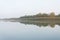 Beautiful reflections on a very still flat river at sunrise