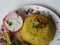 Beautiful restaurant style home made Chicken Biryani with two leg pieces and yogurt dip in a plate isolated on white background