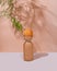 Beautiful retro orange vase with green plant leafes on pastel background. Timeless aesthetic, home interior decor photography