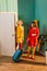 beautiful retro styled girls in colorful dresses entering room with travel bag