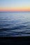 Beautiful rich panorama of the sea landscape in the rays of the setting sun over the horizon. Calm sea at sunset