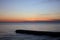 Beautiful rich panorama of the sea landscape in the rays of the setting sun over the horizon. Calm sea at sunset