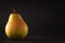 Beautiful ripe yellow pear on black background