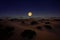 Beautiful rising mon on skyline in desert, AI generated