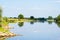 A beautiful river landscape. Flowing river that reflects the sky and plants on the shore.