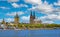 Beautiful river rhine waterfront skyline, two churches, dom, cruise ships, blue summer sky fluffy white clouds