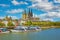 Beautiful river rhine waterfront skyline, two churches, dom, cruise ships, blue summer sky fluffy white clouds