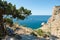 Beautiful rocky mountain landscape with wooden bench and stairway on summer blue sea backdrop