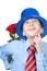 Beautiful romantic boy wearing a shirt, a tie and blue hat holding a rose