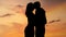 Beautiful romantic couple enjoying amazing sunset, kissing and hugging, closeup