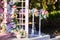 Beautiful romantic festive place made with wooden arch and flowers decorations for outside wedding ceremony in summer garden. Gaze