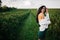 Beautiful romantic young girl in light peasant dress and a hat enjoying a walk around the tea plantation are located among the