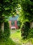 Beautiful and romantical entrance and garden of an old german farmhouse with framework and blooming plants