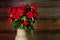 Beautiful roses with frech and wilted buds in ceramic jug on rustic wooden background