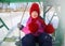 Beautiful rosy-cheeked girl, sitting on a swing with a fine smile