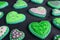 Beautiful royal icing heart shaped cookies scattered on black wooden background