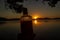 beautiful rum bottle full with rum holding in front of a sunset over Watson Taylors Lake at Crowdy Bay National Park, New South