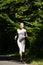 Beautiful running girl. Female runner jogging during outdoor workout on trail in park or forest.
