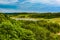 Beautiful rural summer landscape with forest, river, blue sky and white clouds