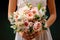 Beautiful rustic wedding bouquet in the hands of the bride close-up