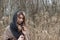 Beautiful sad girl is walking in the field. Photo in brown tones.