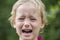 Beautiful sad little girl crying, on summer background