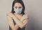 Beautiful sad woman hugging herself the arms with love in respiratory mask. Cold, flu, virus, tonsillitis, respiratory disease,