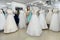 Beautiful saleswoman measuring wedding dress on mannequin