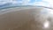 Beautiful sandy beach with bright reflected blue sky.