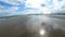 Beautiful sandy beach with bright reflected blue sky.