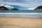 Beautiful sandy beach in san sebastian with monte urgull, island santa clara and monte igueldo, basque country, spain