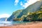 Beautiful sandy beach in Seixal, Madeira Island, Portugal. Green hills covered by tropical forest in the background. People on the