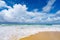 Beautiful sandy beach with wave seafoam clashing on sandy shore turquoise ocean water and blue sky white clouds over sea Natural