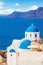 Beautiful Santorini landscape with white church, caldera, sea and sky clouds