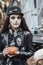 Beautiful scary little girl celebrating halloween. Terrifying black, white half-face makeup and witch costume, stylish image.