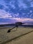 Beautiful scene of a beach by a blue seascape and a purple dramatic sunset sky in Plymouth, Florida