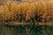 Beautiful scene with a calm reflective mountain lake and an autumn dense forested landscape