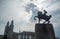 The beautiful scene of cavalier statue and medieval europe building on cloudy sky with sunlight background