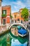Beautiful scene with colorful houses and boats on a small channel in Venice, Italy