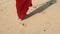 Beautiful scene of suntaned pretty woman in red dress walking bare feet on ocean beach. Girl leaving footprints on