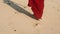 Beautiful scene of suntaned pretty woman in red dress walking bare feet on ocean beach. Girl leaving footprints on