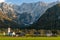 Beautiful scenery of church, houses, and horses feeding on green grass, Slovenia.