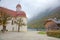 Beautiful scenery of Lake Konigssee with famous Sankt Bartholomae pilgrimage church by the lakeside and autumn mountains in foggy