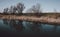 Beautiful scenery of a lake with the reflection of leafless trees