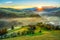 Beautiful scenery landscape Romania village mountains hills fields foggy morning first ray splitting light